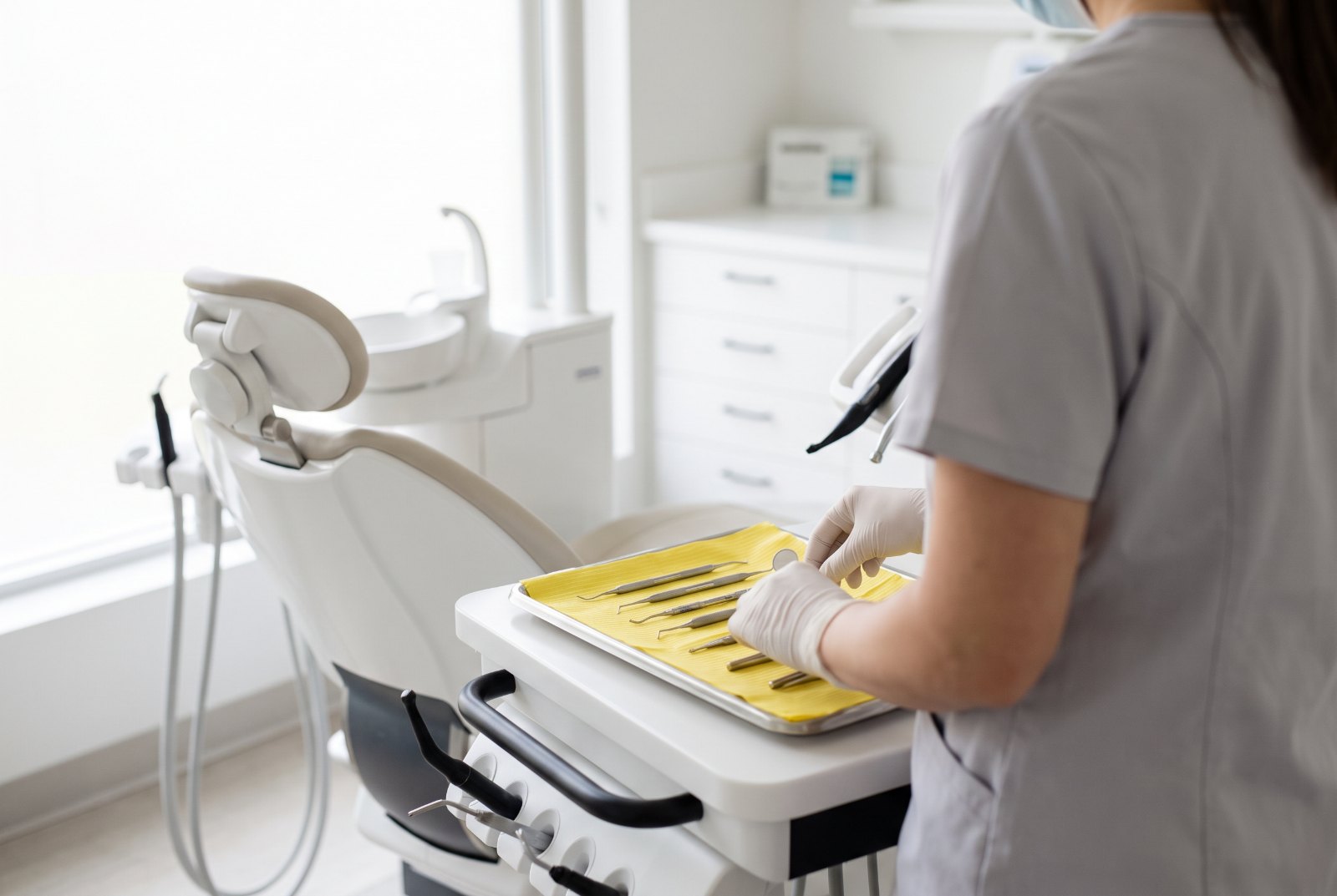 Assistante dentaire préparant les instruments stérilisés à côté du fauteuil